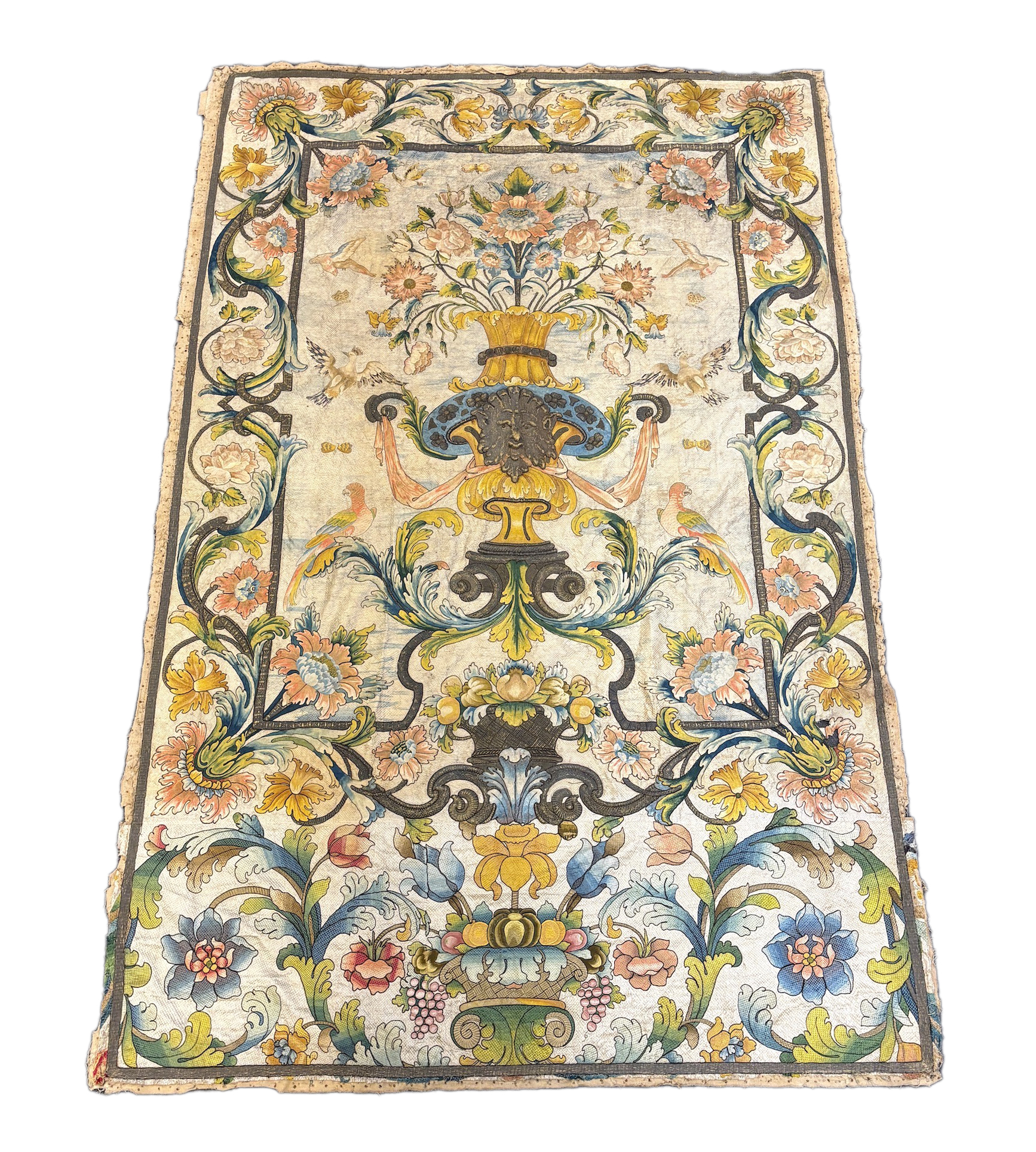 A large early 18th century possibly French polychrome and gold metallic silk embroidered wall hanging, with scrolling vine and floral border. The central motifs embroidered with an elaborate metallic thread cartouche fra